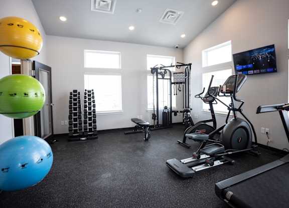 Modern gym with rows of cardio equipment.