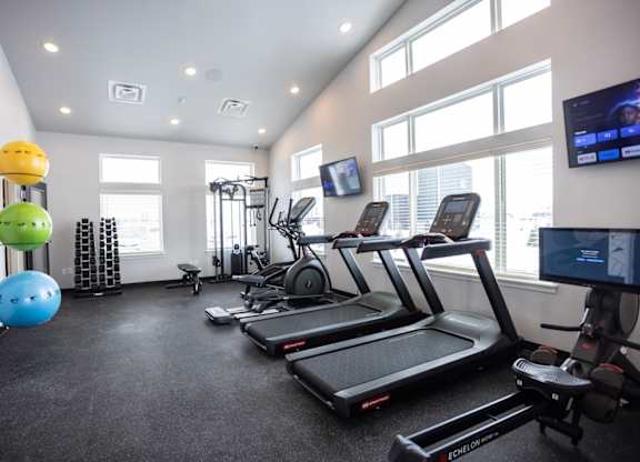 Modern gym with rows of cardio equipment.