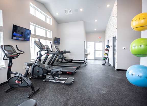 Modern gym with rows of cardio equipment.