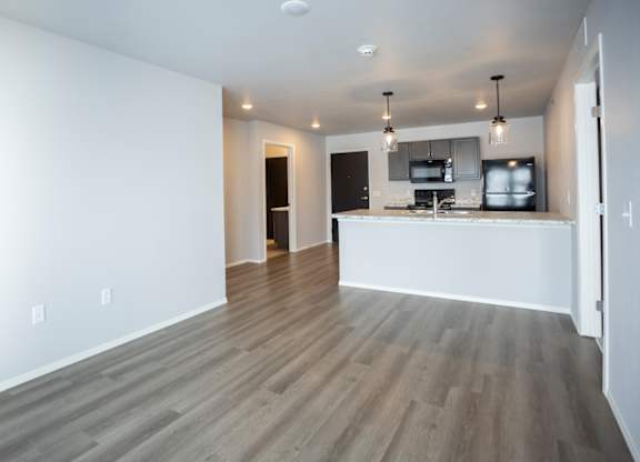 Modern open-concept kitchen and living area with black appliances.
