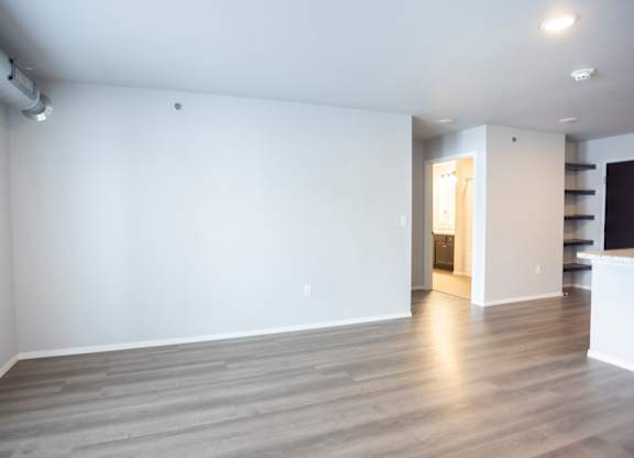 Empty living room with large, bright windows.