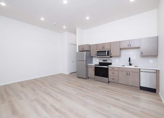 A kitchen with wooden floors and stainless steel appliances.