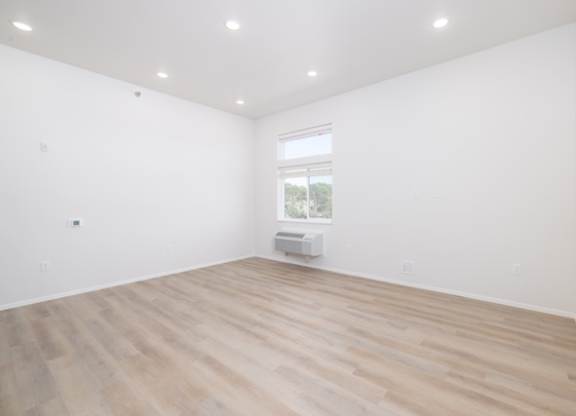 A room with wooden flooring and a window.