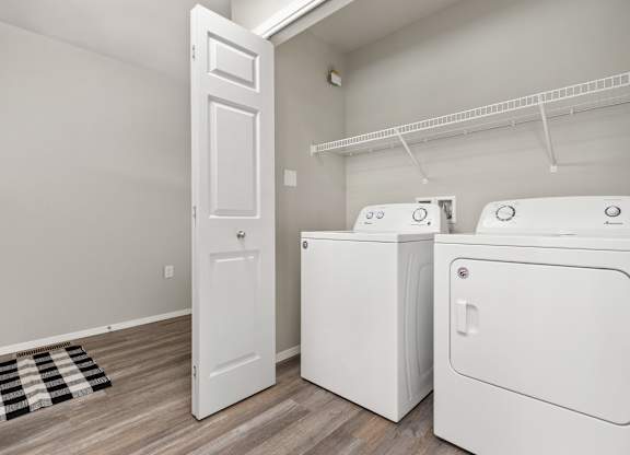A laundry room with a white door and two washing machines.