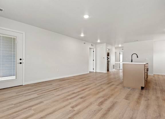 A room with wooden flooring and white walls.