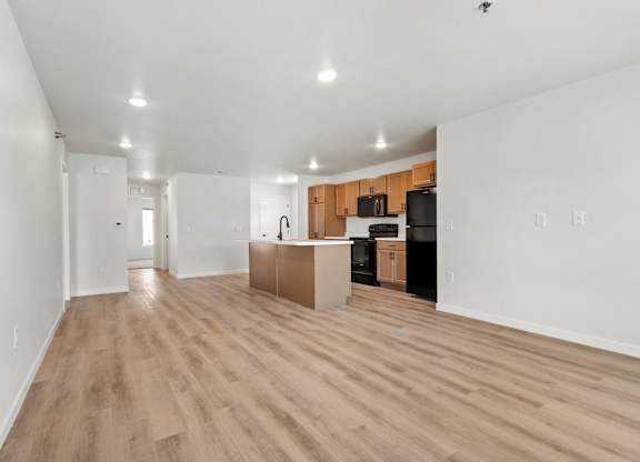 A kitchen area with wooden floors and white walls.