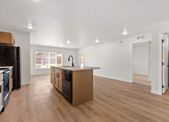 A kitchen with wooden floors and appliances.