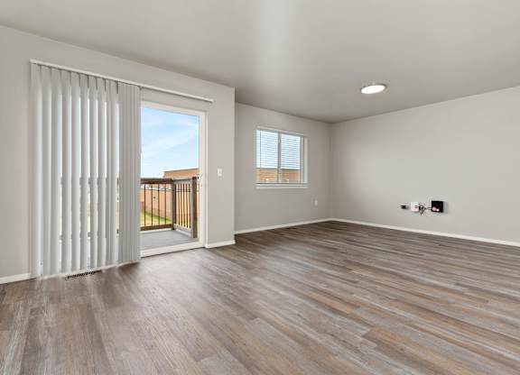 A room with a sliding glass door leading to a balcony.