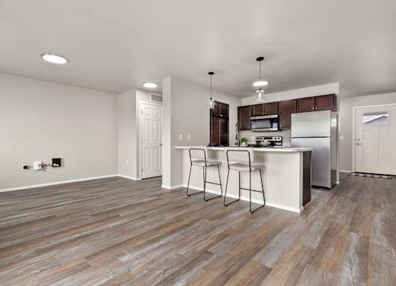 A kitchen with a white counter and brown flooring.