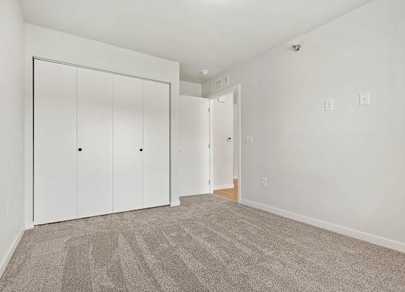 A room with a carpeted floor and a white door.