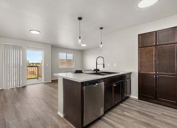 A modern kitchen with dark wood floors and stainless steel appliances.