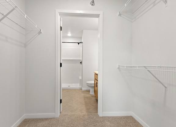 A white hallway with a toilet visible through the open door.