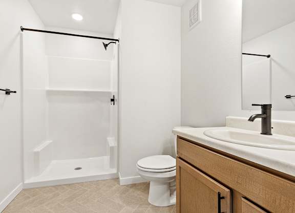 A white toilet sits next to a sink in a bathroom.