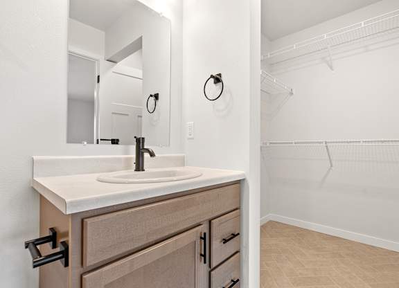 A bathroom with a sink, mirror, and a closed door.