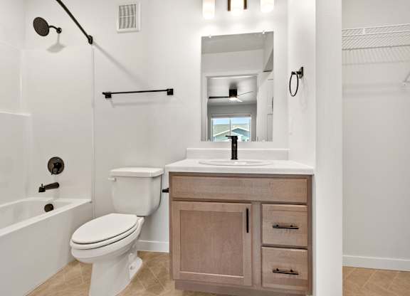 A white toilet sits next to a sink in a bathroom.