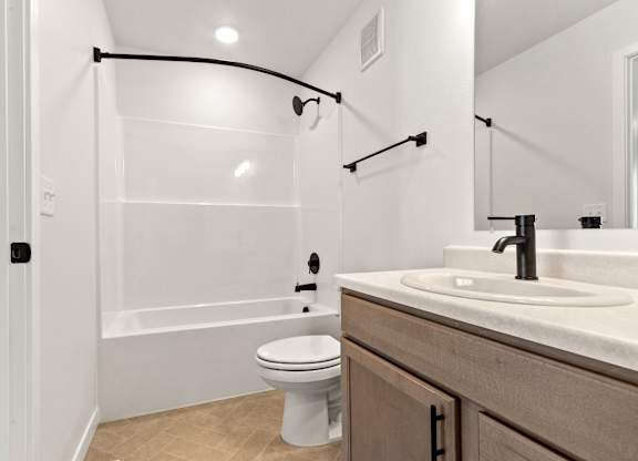 A bathroom with a toilet, sink, and a glass shower door.