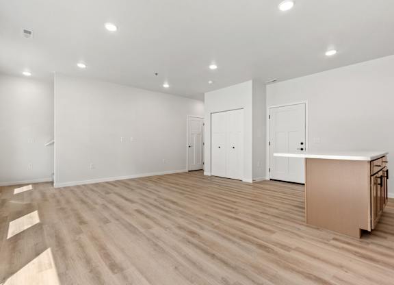 A room with wooden flooring and white walls.