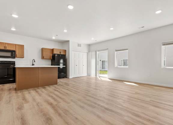 A spacious kitchen with wooden floors and modern appliances.