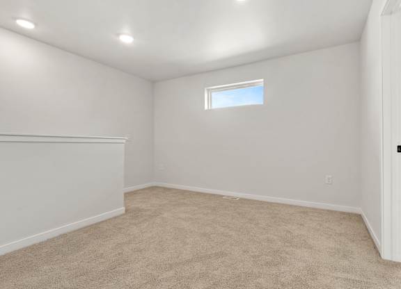 A room with a window and carpeted floor.