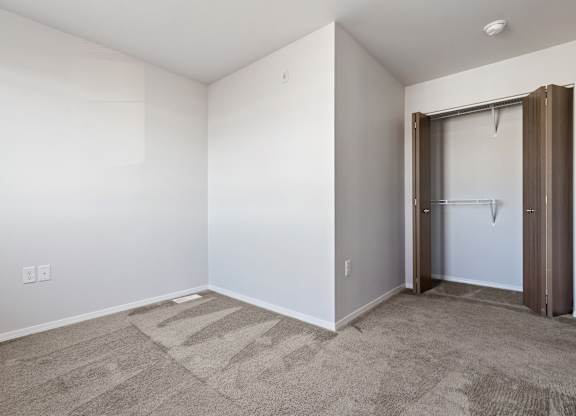 A room with a carpeted floor and a door.