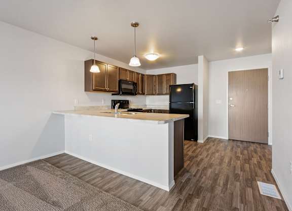 A kitchen with a white counter and wooden cabinets.