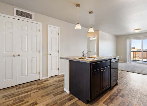 A kitchen with a black island and white cabinets.
