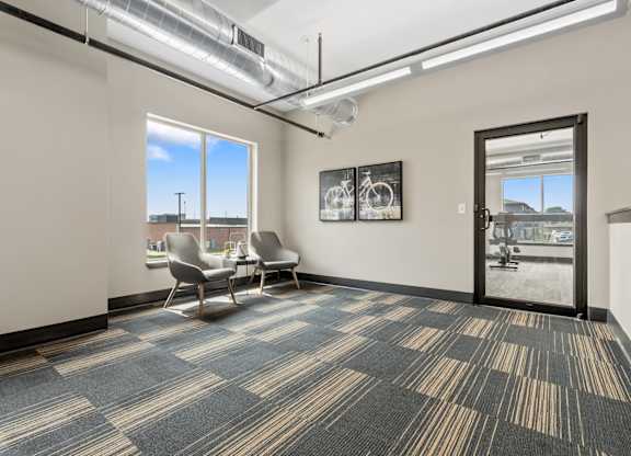A room with a carpeted floor and a view of the outside through a window.