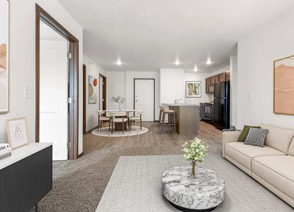 A living room with a white couch and a coffee table with a plant on it.