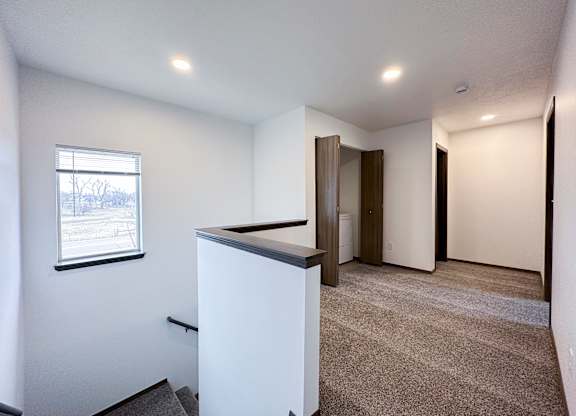 A room with a white cabinet and a window with a view of a snowy landscape.