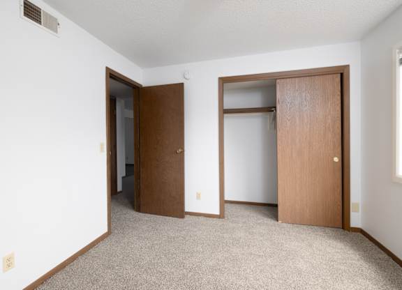 A room with two doors and a carpeted floor.