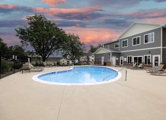 A swimming pool in a backyard with a house in the background.