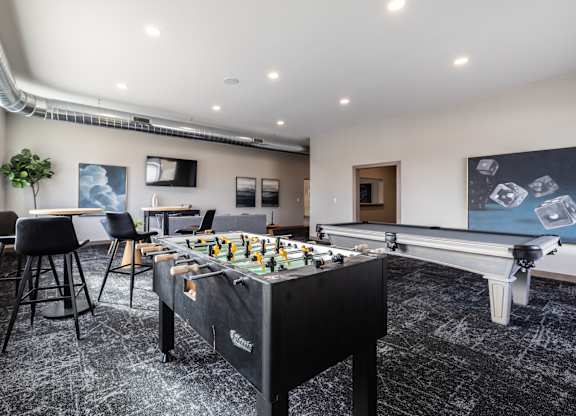 A foosball table is in the middle of a room with a black and white floor.