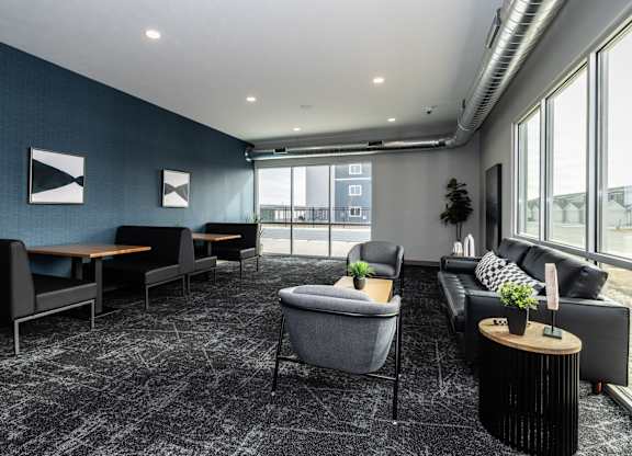 A modern living room with a grey carpet and black and white furniture.