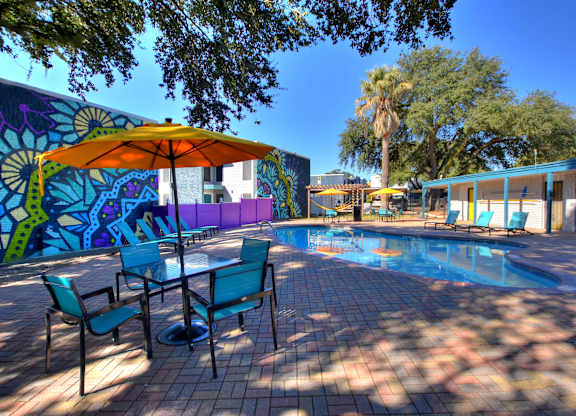 Resort style pool with colorful mural and patio seating at Azure Apartments, Austin, Texas