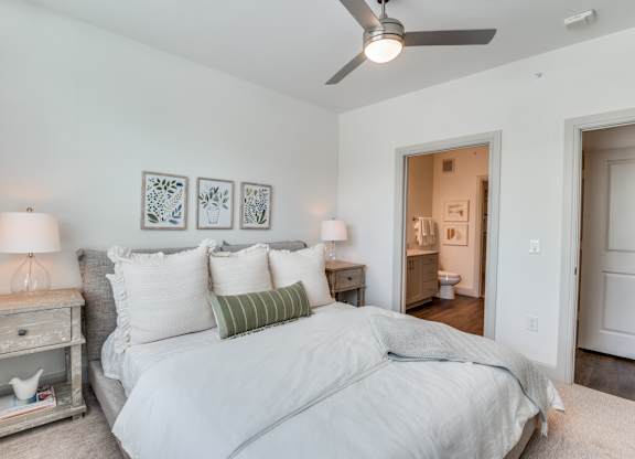 A bedroom with a large bed and a ceiling fan.