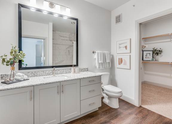 A bathroom with a white toilet, sink, and mirror.