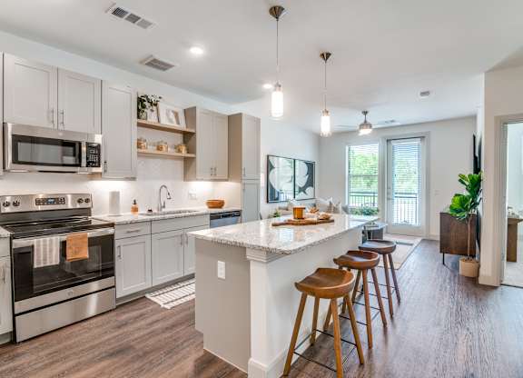 A kitchen with a white island and wooden floors.