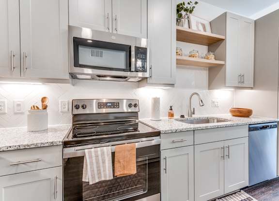 A modern kitchen with a stove, microwave, and oven.