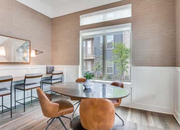 A dining room with a table and chairs.