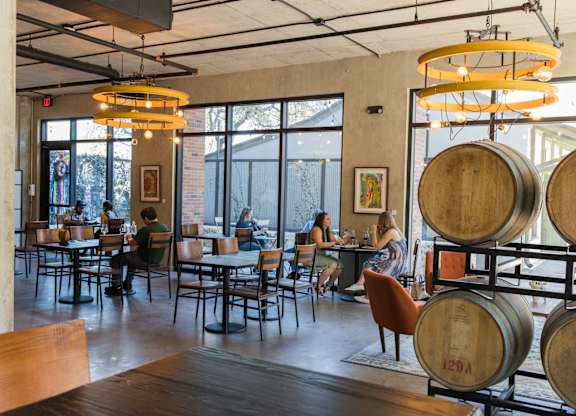 Tasting room with wine barrels and seating at THE'68 Apartments, San Antonio, Texas
