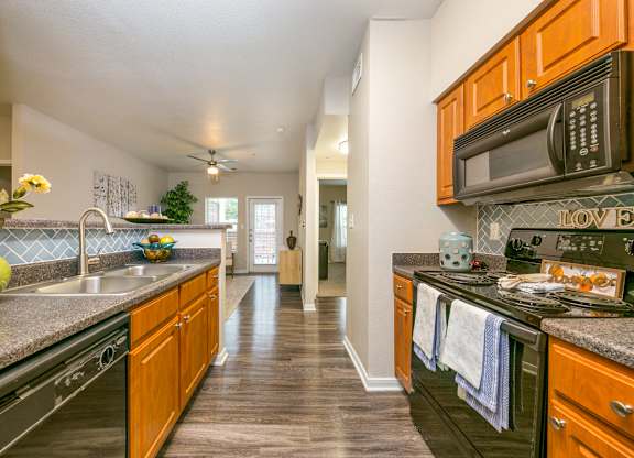 a kitchen with wood cabinets and black appliances at Sunrise Canyon, Texas, 78148