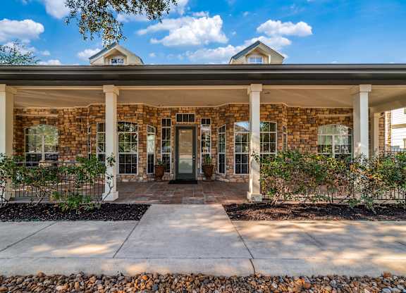 a brick house with white pillars and a black door at Sunrise Canyon, Universal City, Texas