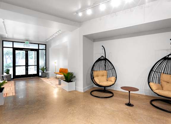 Modern lobby entrance with hanging egg chairs at THE'68 Apartments, San Antonio, TX