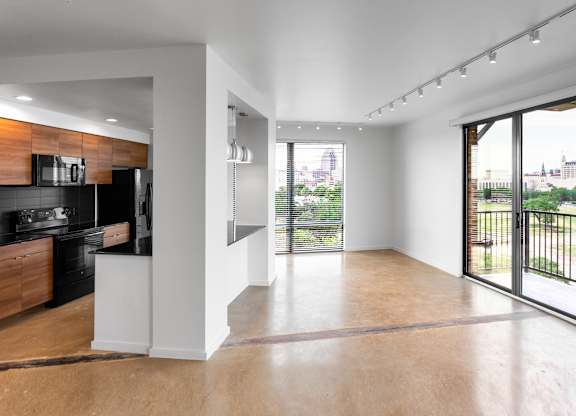 Open living room with balcony and city views at THE'68 Apartments, San Antonio, 78205