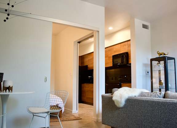 Modern living room with open kitchen view at THE'68 Apartments, San Antonio