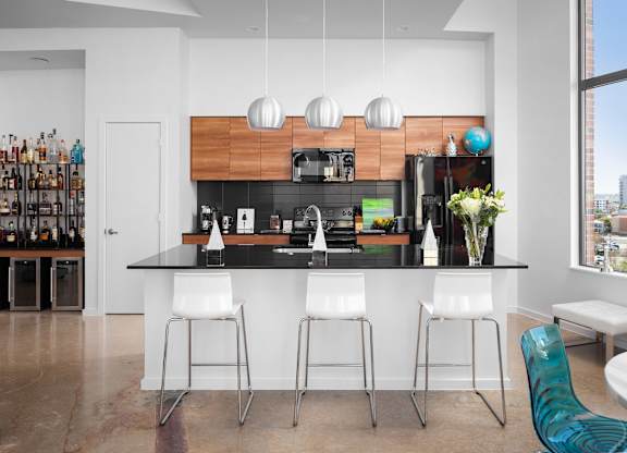 Modern kitchen with breakfast bar and pendant lights at THE'68 Apartments, San Antonio, TX 78205