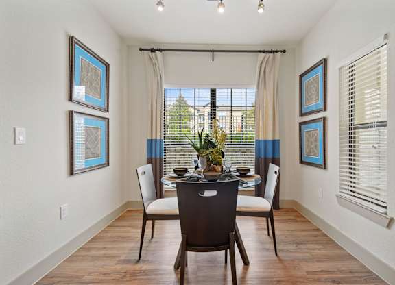 a dining room with a table and chairs in front of a window with blinds at Alvista Round Rock, Round Rock, TX, 78664