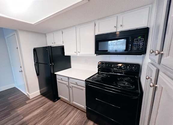 a kitchen with black appliances and white cabinets at Northchase, Austin, TX, 78753