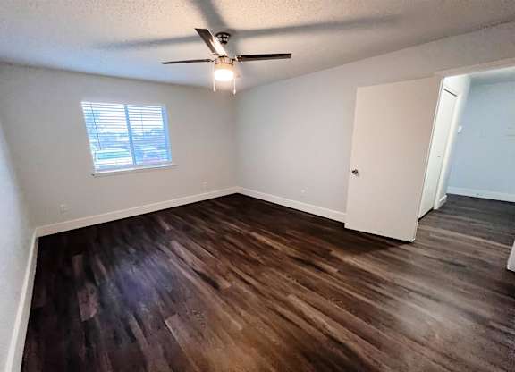 an empty living room with wooden floors and a ceiling fan at Northchase,Texas