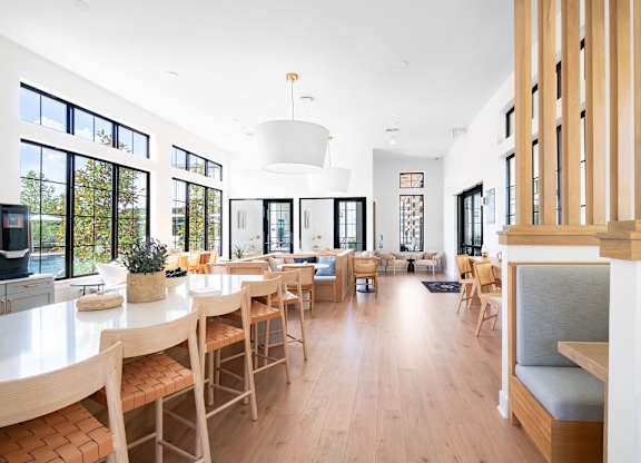 A modern dining room with wooden chairs and a white table.